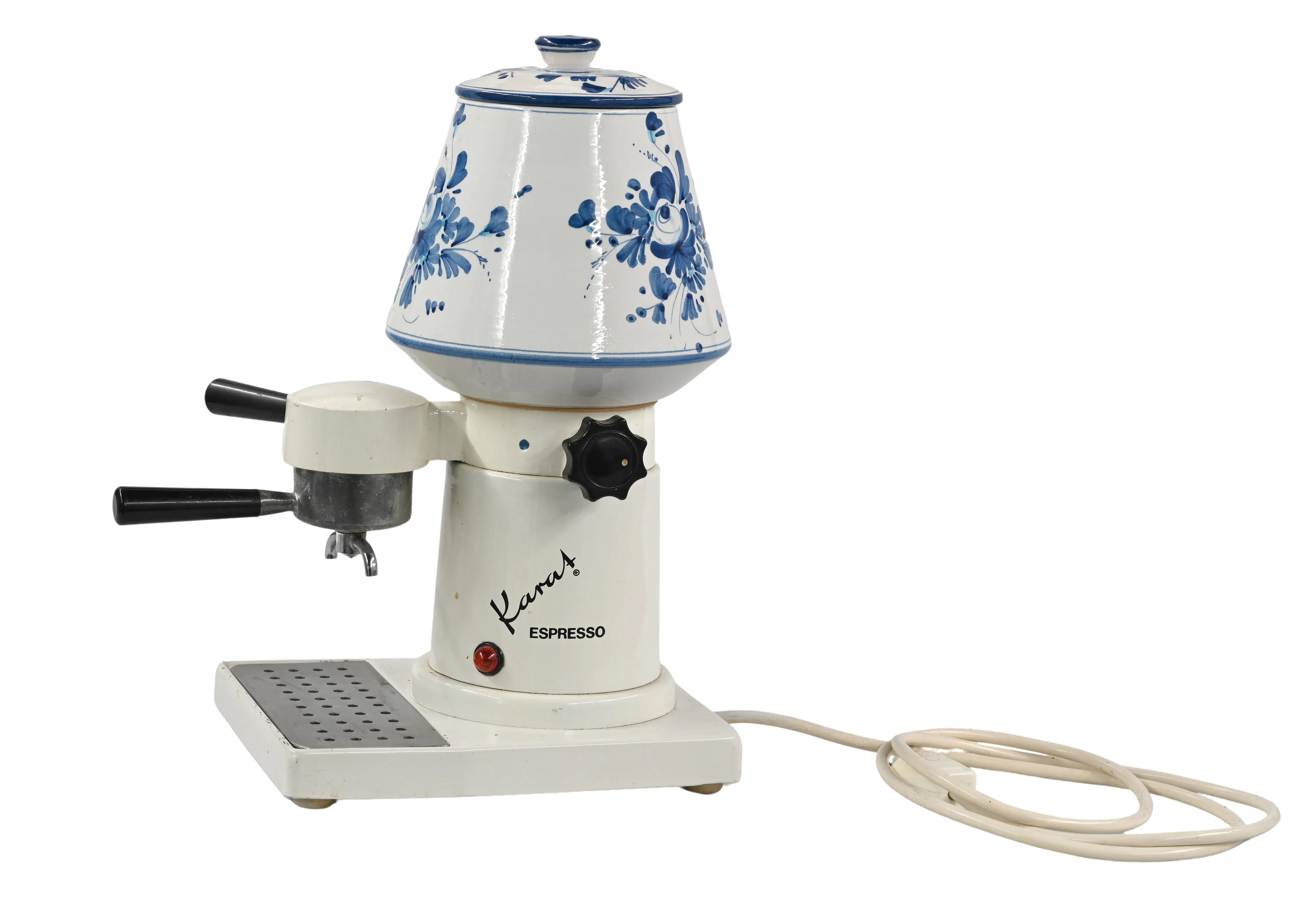 Liechtensteinisches LandesMuseum, 2023/0048, Foto: Sven Beham

1963 gründete der gelernte Mechaniker William Hoop (1927–2011) in Eschen die Firma William Hoop Apparatebau. Diese stellte zwischen 1963 und 1980 die mit einem Wasser-behälter ausgestattete, elektrische Kaffeemaschine Hoop-Karat her und verkaufte diese international. Der Behälter aus bemalter, handgefertigter Keramik fasste zwei Liter Wasser. Das erhitzte Wasser wurde durch einen mit Pulver befüllten Brühkopf gepresst und ergab in zwei Minuten eine grosse Tasse Kaffee. Das Unternehmen ging 1980 Konkurs.