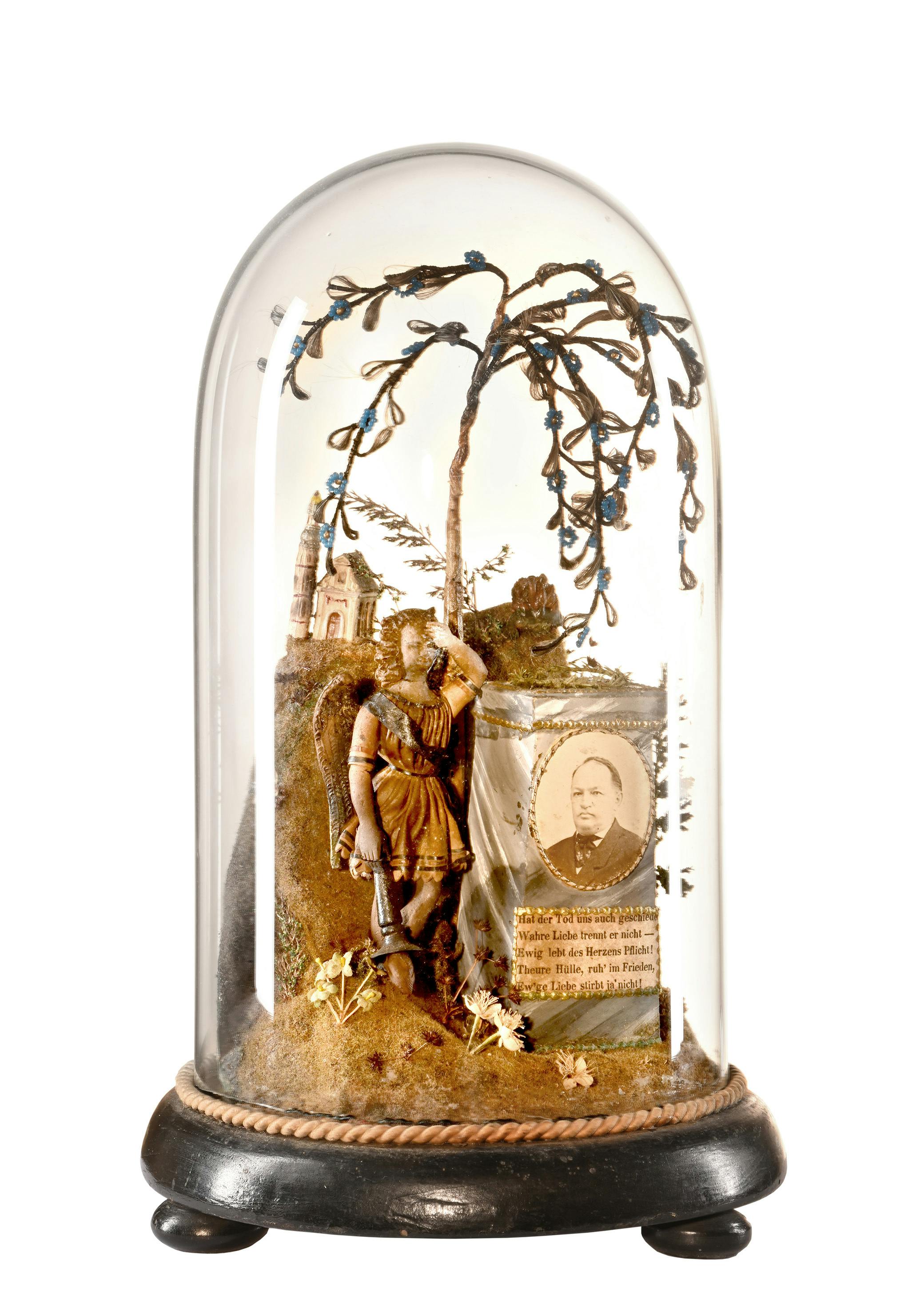 Trauernder Engel vor Grabmal mit Trauerweide in Glassturz